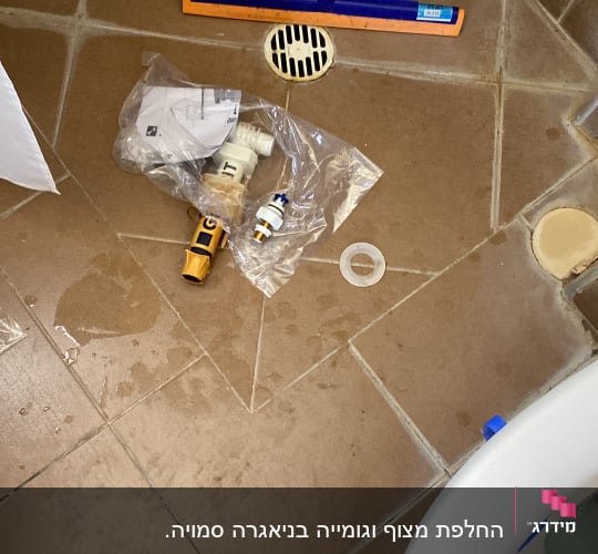 כלים וחלקים לעבודת אינסטלציה על רצפת חדר אמבטיה
